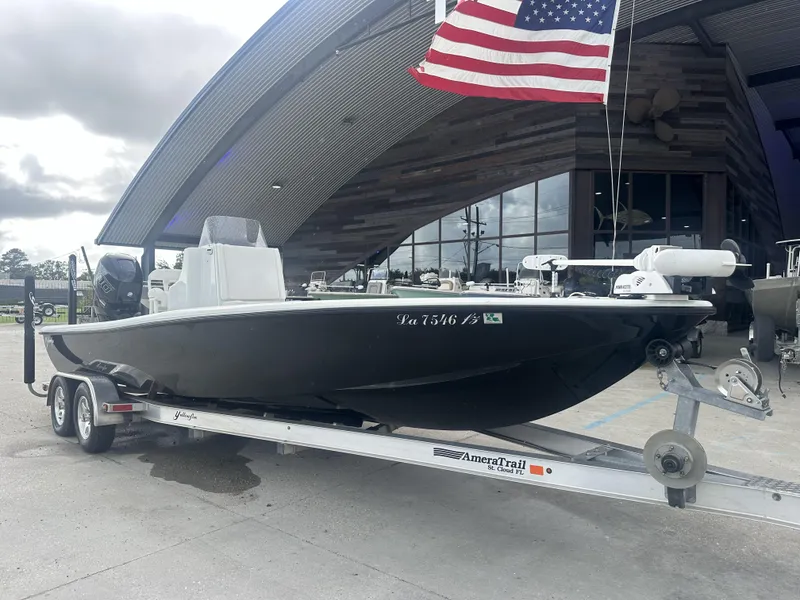 Slide: The Image of 2012 Yellowfin 24 Bay boat on trailer, parked outside under American flag. - 4