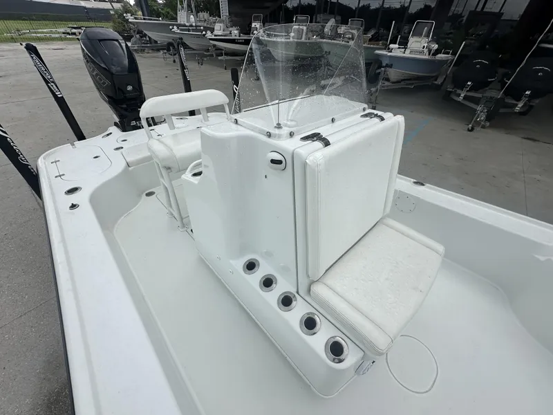 Slide: The Image of 2012 Yellowfin 24 Bay boat interior with seating and console, parked outdoors. - 5