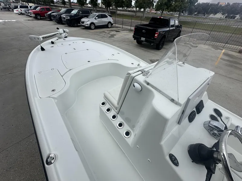 Slide: The Image of 2012 Yellowfin 24 Bay boat with console and seating, parked near vehicles. - 7