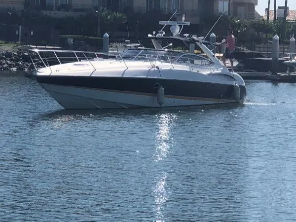 Slide: The Image of Sunseeker Superhawk 48 Mk II yacht, 2000 model, cruising on calm water near a marina. - 2