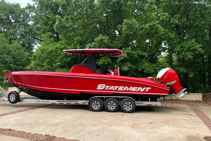 The Image of Red 2019 Statement 350 Open boat on trailer, parked outdoors with lush green trees. - 0