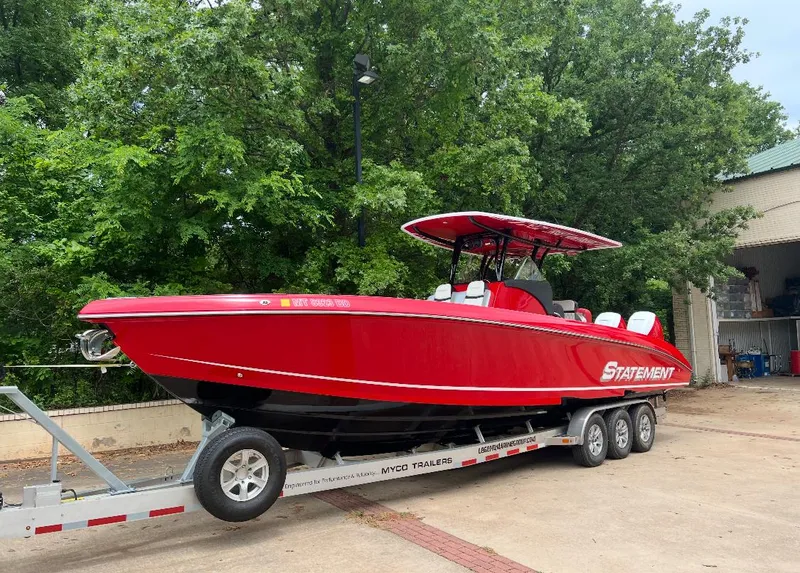 Slide: The Image of Red 2019 Statement 350 Open boat on trailer, parked outdoors near trees. - 1