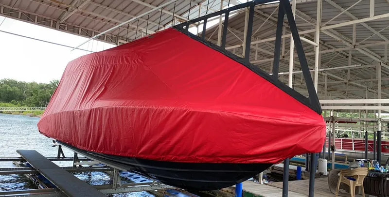 Slide: The Image of 2019 Statement 350 Open boat covered with a red tarp in a dock. - 11
