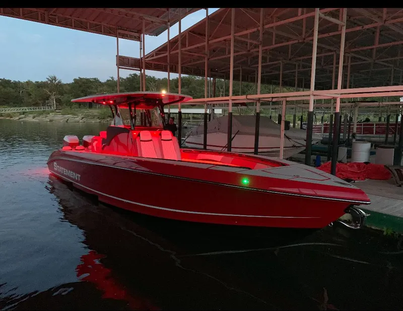 Slide: The Image of Red 2019 Statement 350 Open boat docked under a covered marina at dusk. - 4