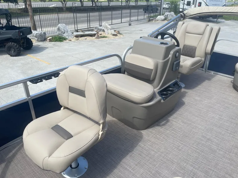 Slide: The Image of 2025 Sun Tracker Bass Buggy 16 XL pontoon boat interior with beige seating and steering console. - 11