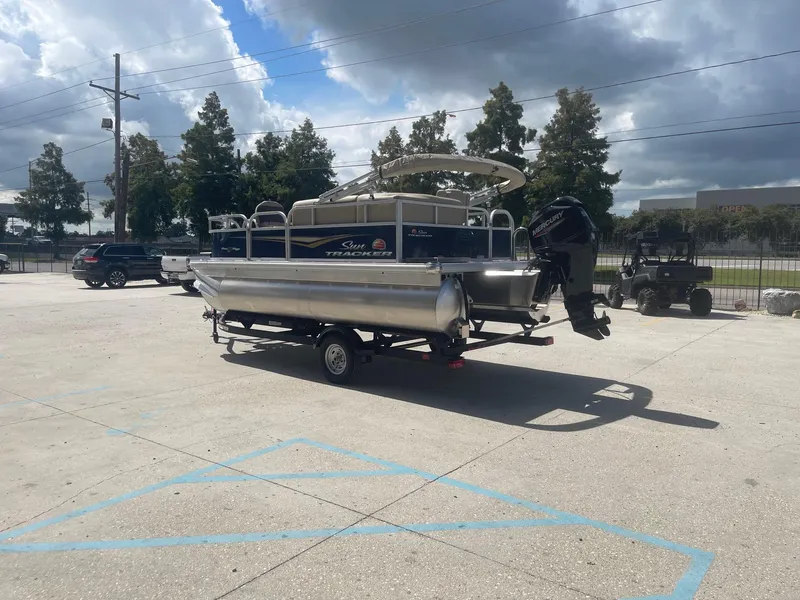 Slide: The Image of 2025 Sun Tracker Bass Buggy 16 XL pontoon boat on trailer in parking lot. - 5