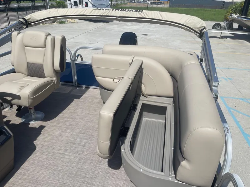 Slide: The Image of 2025 Sun Tracker Bass Buggy 16 XL pontoon boat with beige seating and storage compartment. - 16
