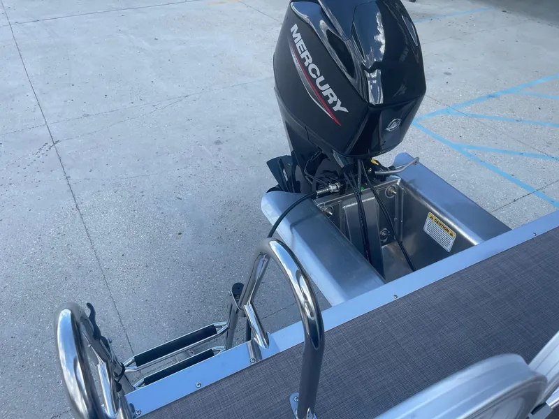 Slide: The Image of 2025 Sun Tracker Bass Buggy 16 XL with Mercury outboard motor, docked on concrete surface. - 21