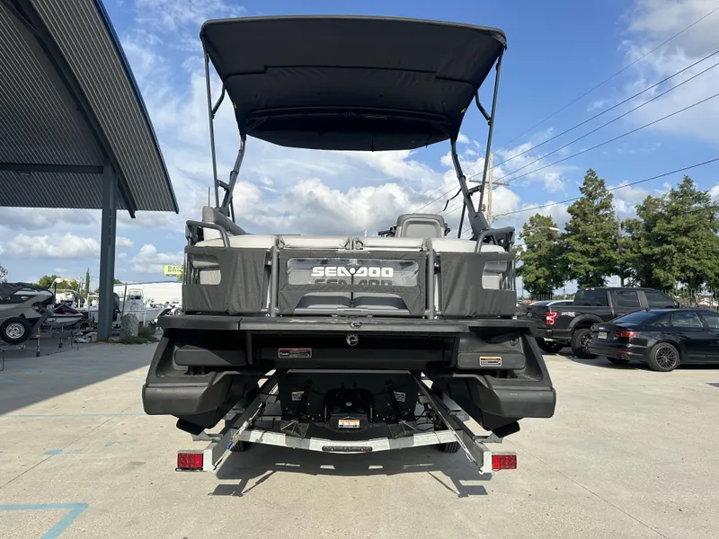 Slide: The Image of 2023 Sea-Doo Switch Cruise 21' boat, rear view, parked outdoors under a clear sky. - 14
