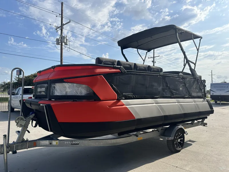 Slide: The Image of 2023 Sea-Doo Switch Cruise 21' boat on trailer, red and black design, parked outdoors. - 3