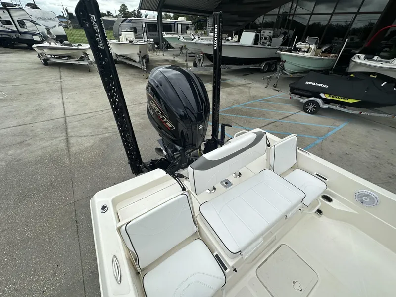 Slide: The Image of 2023 Skeeter SX230 boat with outboard motor, docked in a marina. - 12