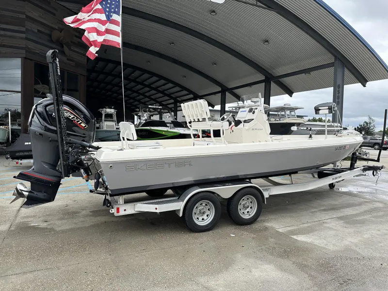 Slide: The Image of 2023 Skeeter SX230 boat on trailer, displayed outdoors under a canopy. - 18