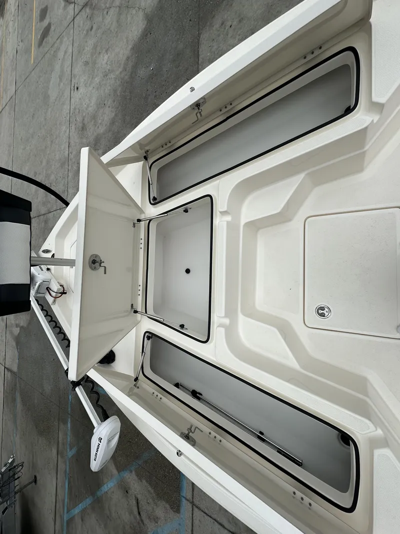 Slide: The Image of 2023 Skeeter SX230 boat interior with open storage compartments on a concrete surface. - 19