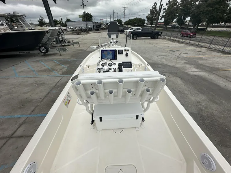 Slide: The Image of 2023 Skeeter SX230 boat interior with steering console and rod holders in a parking lot. - 24