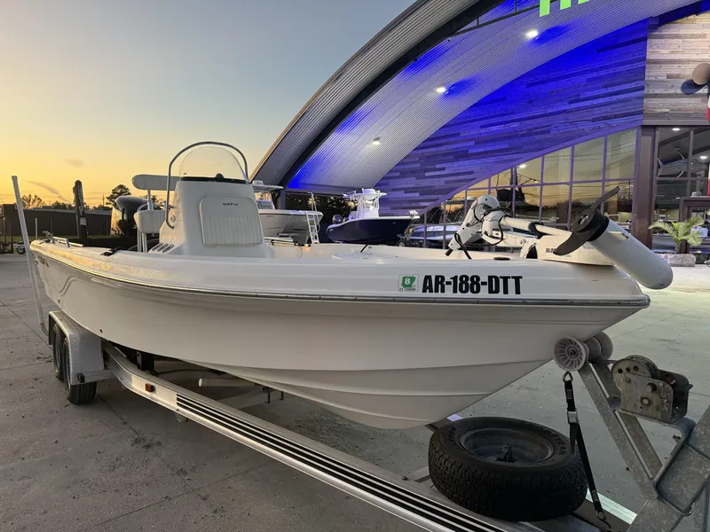 Slide: The Image of 2006 Sea Fox 225 Bay Fisher boat on trailer at sunset, parked near modern building. - 1