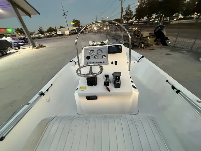 Slide: The Image of 2006 Sea Fox 225 Bay Fisher boat console with steering wheel and controls at a marina. - 12