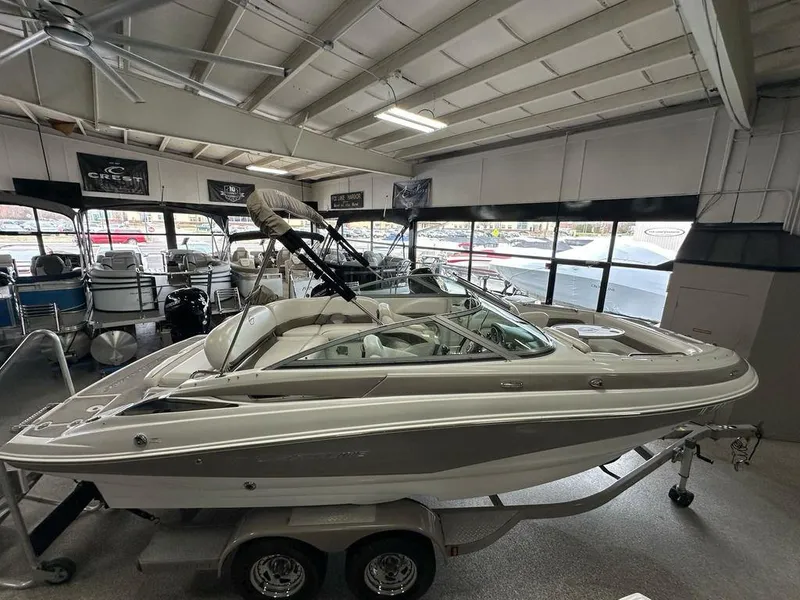 Slide: The Image of 2012 Crownline E1 boat displayed indoors on a trailer. - 1