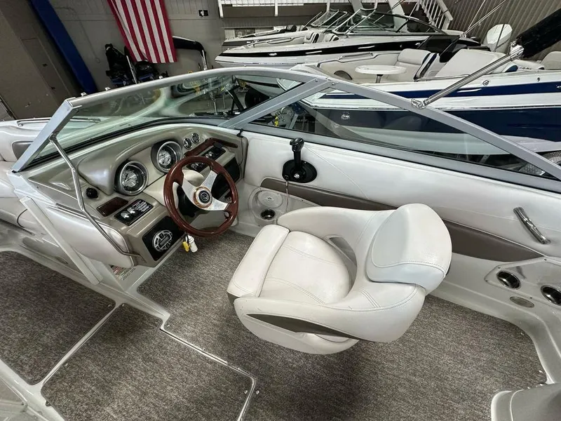 Slide: The Image of 2012 Crownline E1 boat interior with steering wheel and dashboard, featuring plush seating. - 10