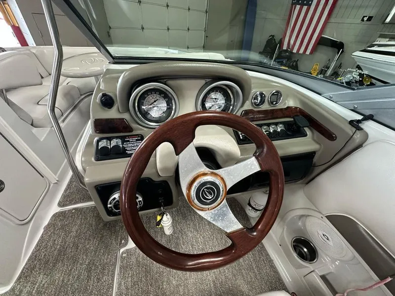 Slide: The Image of 2012 Crownline E1 boat dashboard with wooden steering wheel and gauges. - 11