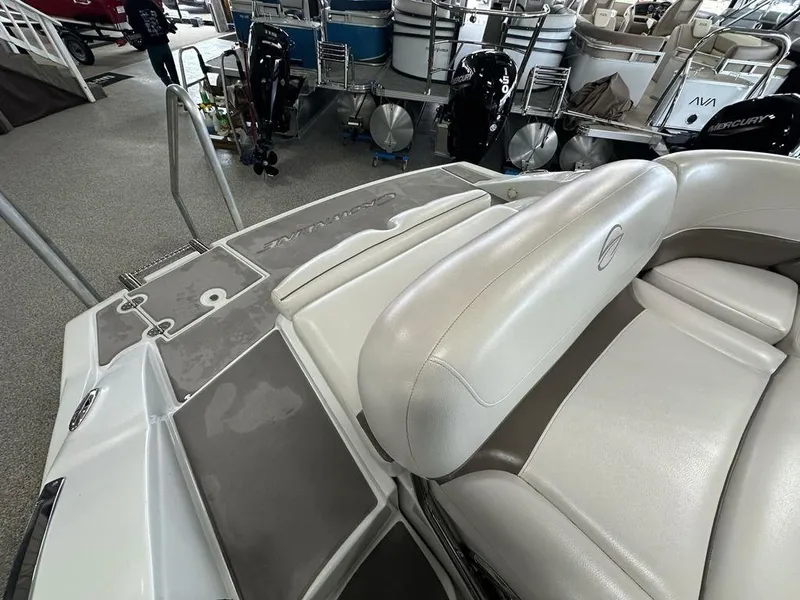 Slide: The Image of 2012 Crownline E1 boat interior with beige seating and deck details in showroom. - 15