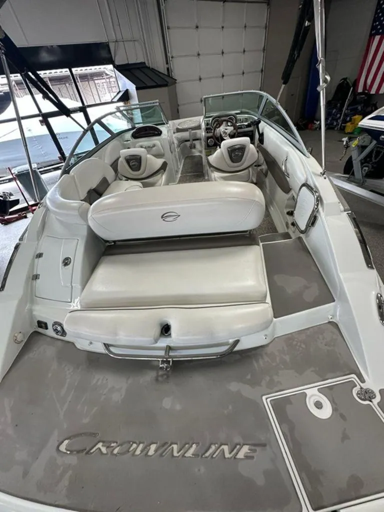 Slide: The Image of 2012 Crownline E1 boat interior with seating and steering wheel in a garage setting. - 2