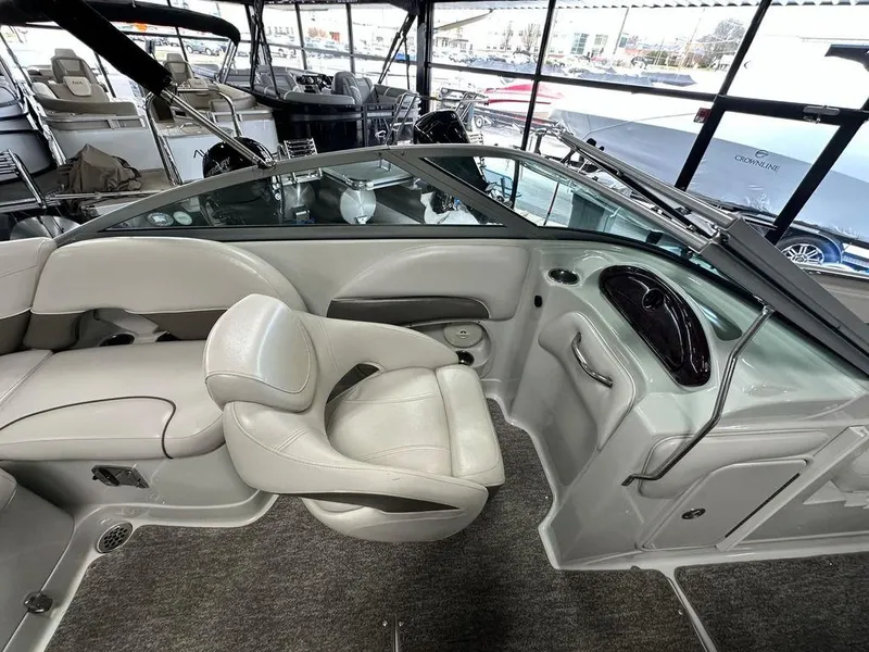 Slide: The Image of 2012 Crownline E1 boat interior with beige seating and modern dashboard. - 9