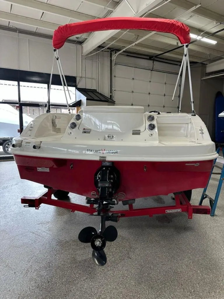Slide: The Image of Red and white 2011 Starcraft 2000 boat with canopy in a garage. - 14
