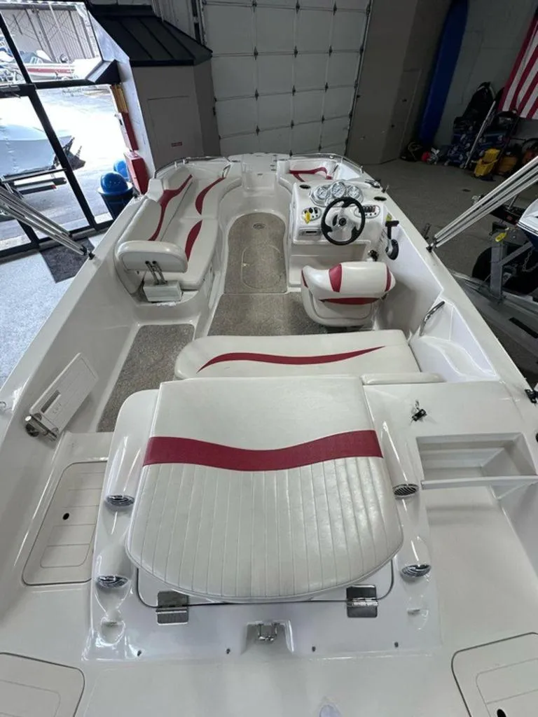 Slide: The Image of Interior of 2011 Starcraft 2000 boat with white and red seating, steering wheel, and storage compartments. - 2