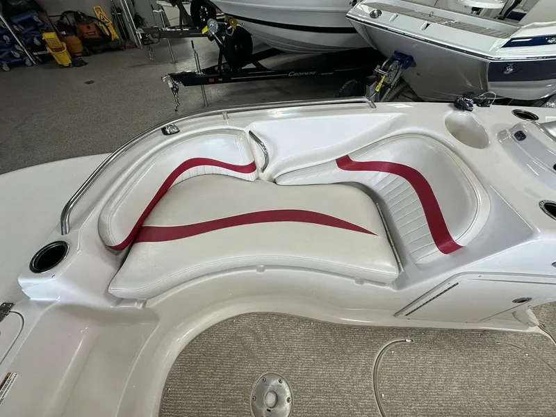 Slide: The Image of White and red seating on a 2011 Starcraft 2000 boat, in a showroom setting. - 5
