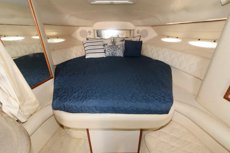 Slide: The Image of 2001 Sea Ray 340 Sundancer cabin with blue bedding and decorative pillows. - 11