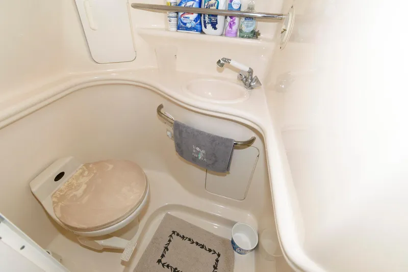 Slide: The Image of Compact bathroom in 2001 Sea Ray 340 Sundancer yacht with toilet, sink, and toiletries. - 13