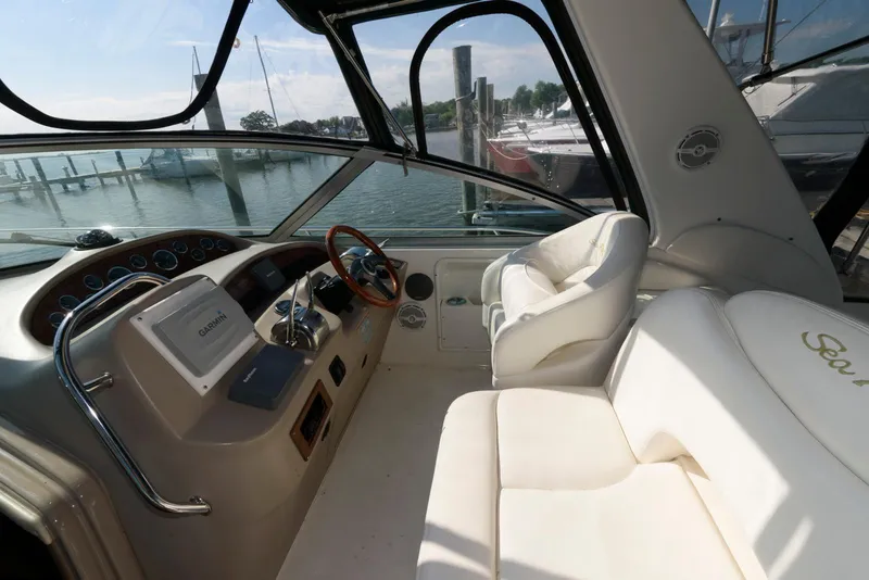 Slide: The Image of Interior view of 2001 Sea Ray 340 Sundancer yacht with white seating and steering console. - 5