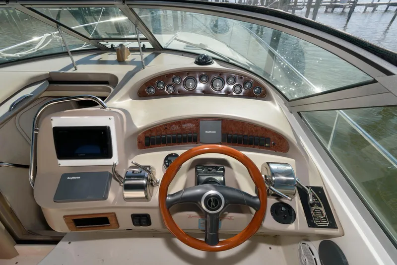 Slide: The Image of 2001 Sea Ray 340 Sundancer helm with wood-accented steering wheel and modern controls. - 7