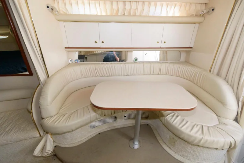 Slide: The Image of 2001 Sea Ray 340 Sundancer interior with curved seating and table. - 9
