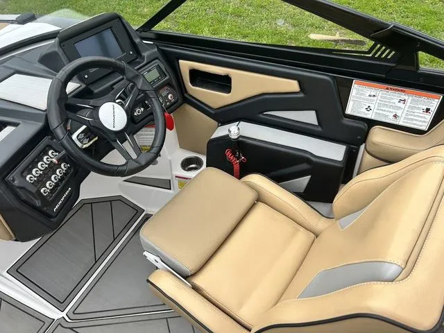 Slide: The Image of 2019 Moomba Makai™ boat interior with tan seating, steering wheel, and control panel. - 12