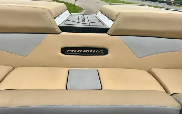 Slide: The Image of 2019 Moomba Makai™ boat interior with beige seating and logo. - 16