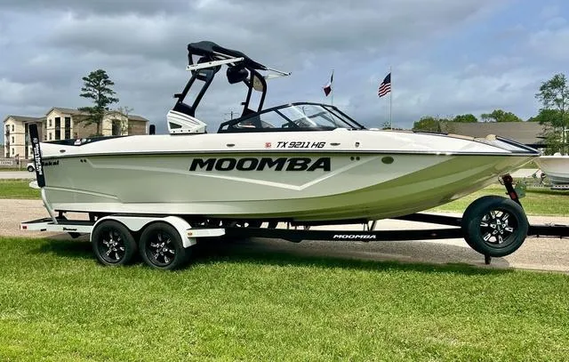 Slide: The Image of 2019 Moomba Makai™ boat on trailer, parked on grass with flags in background. - 3