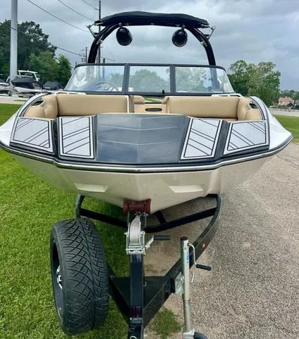 Slide: The Image of 2019 Moomba Makai™ boat on trailer, parked on grass, showcasing sleek design and spacious interior. - 5