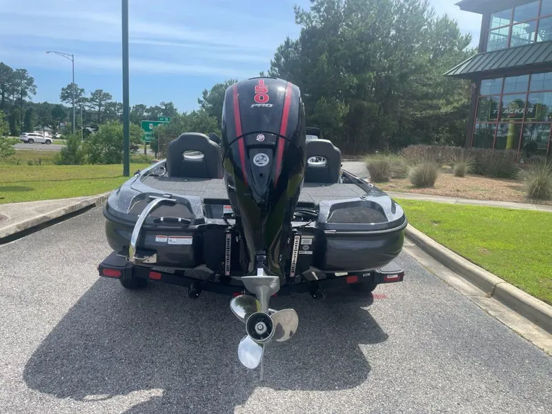 Slide: The Image of 2025 Nitro Z18 Pro boat with powerful outboard motor, parked outdoors on a sunny day. - 2