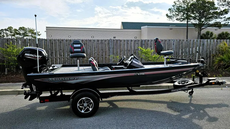 The Image of 2025 Ranger RT178 fishing boat with Mercury engine on a trailer, parked outdoors. - 0