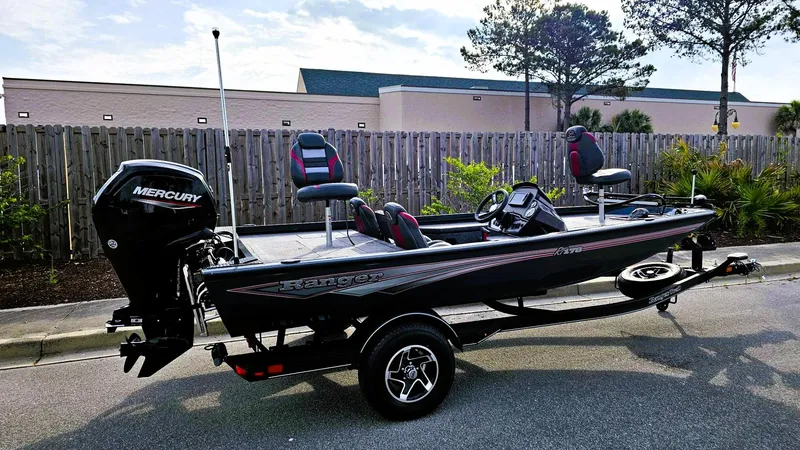Slide: The Image of 2025 Ranger RT178 fishing boat with Mercury engine on trailer, parked outdoors. - 11