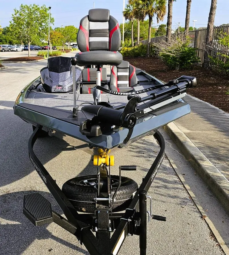 Slide: The Image of 2025 Ranger RT178 fishing boat on trailer, parked outdoors with lush greenery. - 5