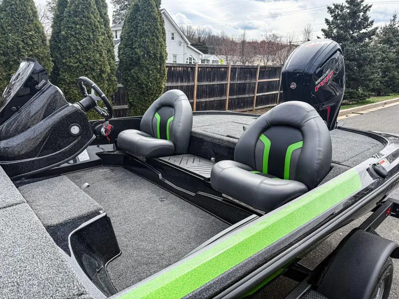 Slide: The Image of 2025 Nitro Z17 boat interior with green-accented seats and steering wheel, parked outdoors. - 3