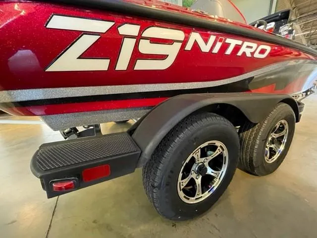 Slide: The Image of 2025 Nitro Z19 boat with dual wheels and red exterior in a showroom. - 5