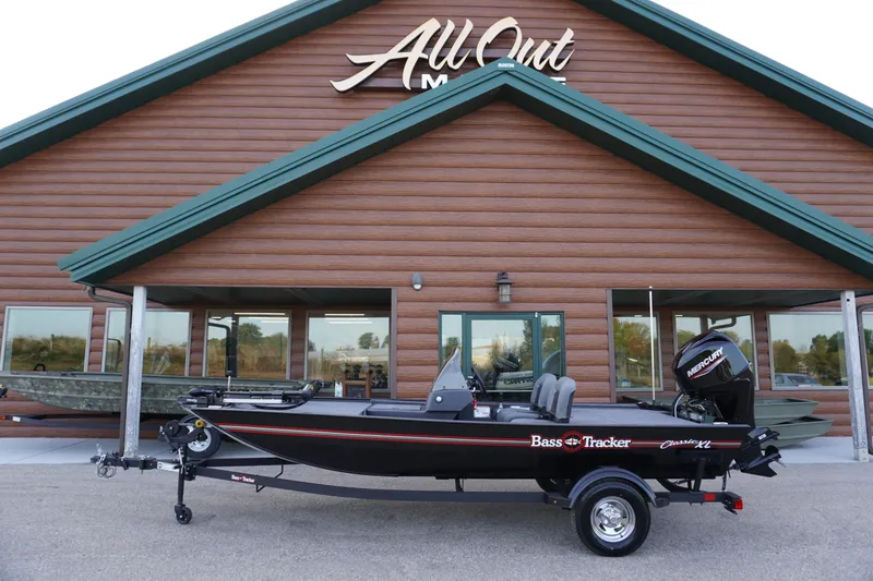 The Image of 2025 Tracker Bass Tracker Classic XL boat displayed outside a wooden building. - 61
