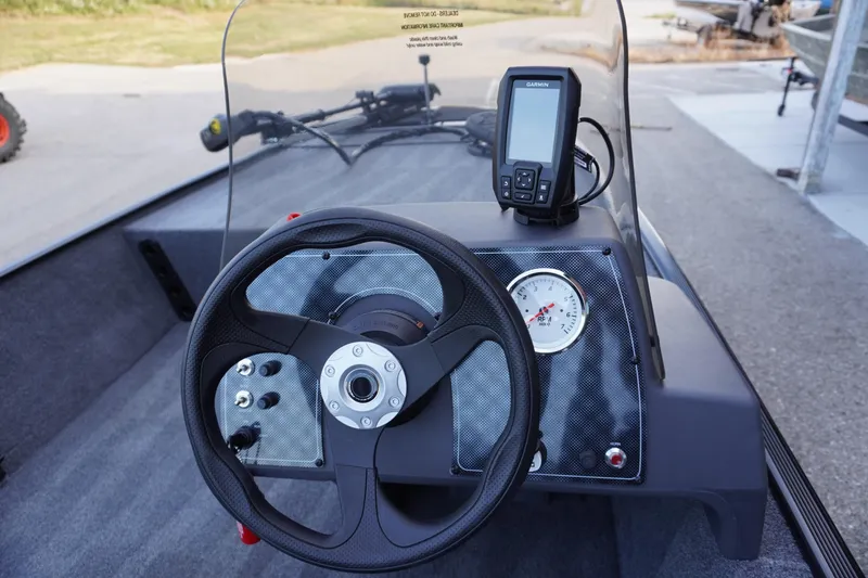 Slide: The Image of 2025 Tracker Bass Tracker Classic XL dashboard with steering wheel and Garmin device. - 73