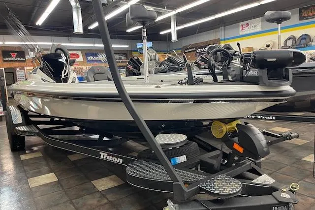 Slide: The Image of 2025 Triton 21XP Patriot boat displayed in showroom, featuring sleek design and advanced equipment. - 0