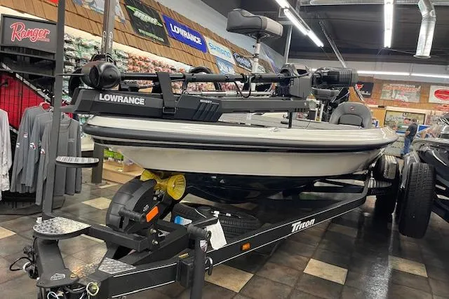 Slide: The Image of 2025 Triton 21XP Patriot boat displayed indoors with Lowrance equipment. - 2