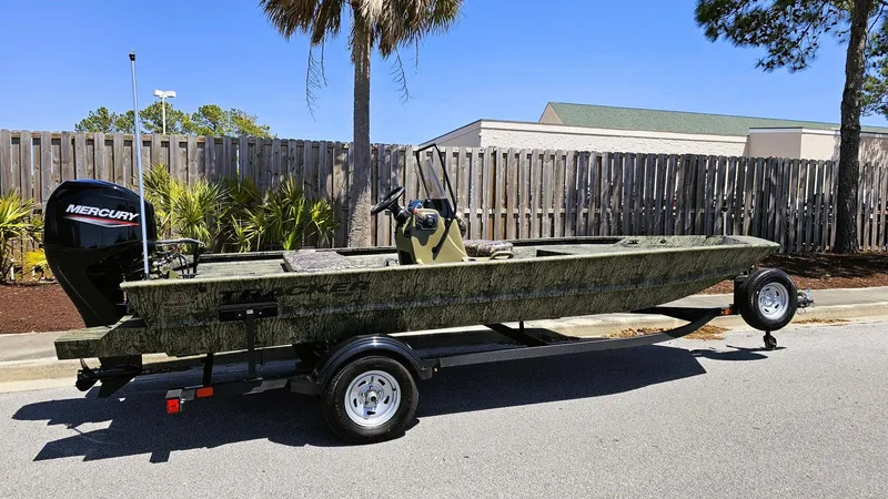 Slide: The Image of 2025 Tracker Grizzly 1860 CC boat on trailer, parked outdoors. - 8