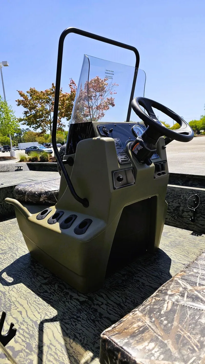 Slide: The Image of 2025 Tracker Grizzly 1860 CC boat console with steering wheel and controls. - 9